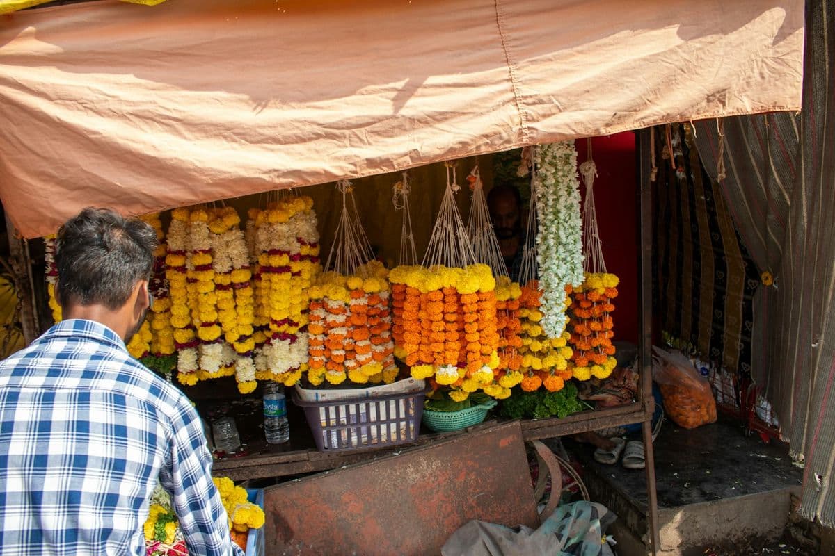 A garland stall hung with strings of marigold under a canvas awning