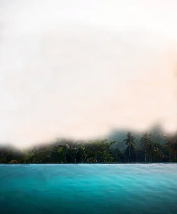 Misty hills above an infinity pool at dawn
