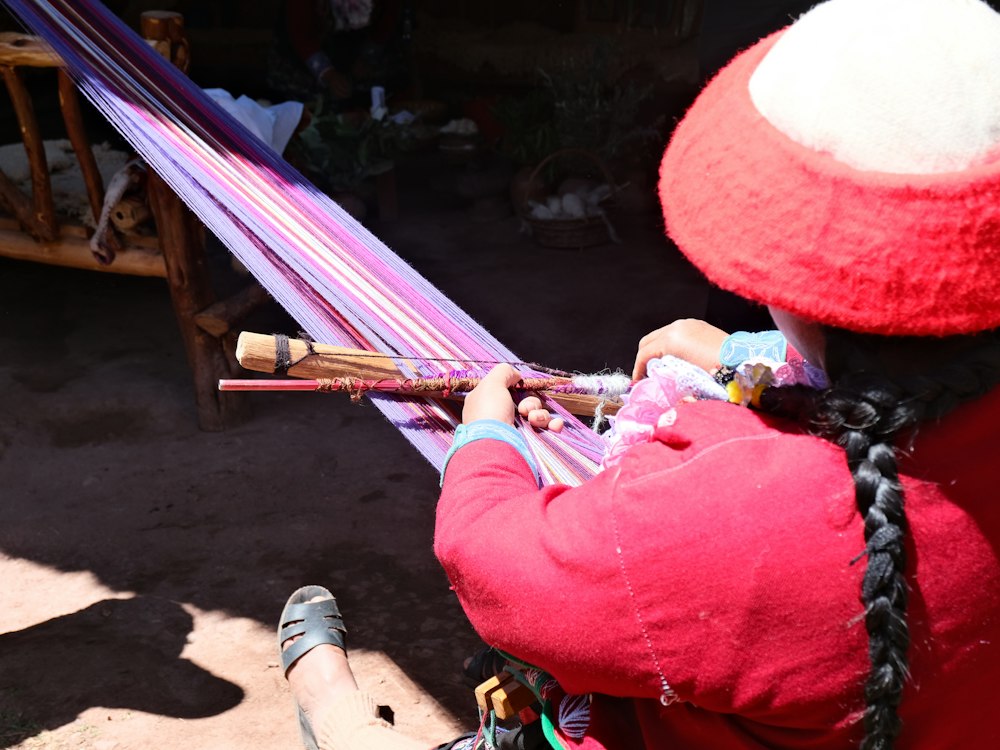 Woman weaving colorful fabric on a loom