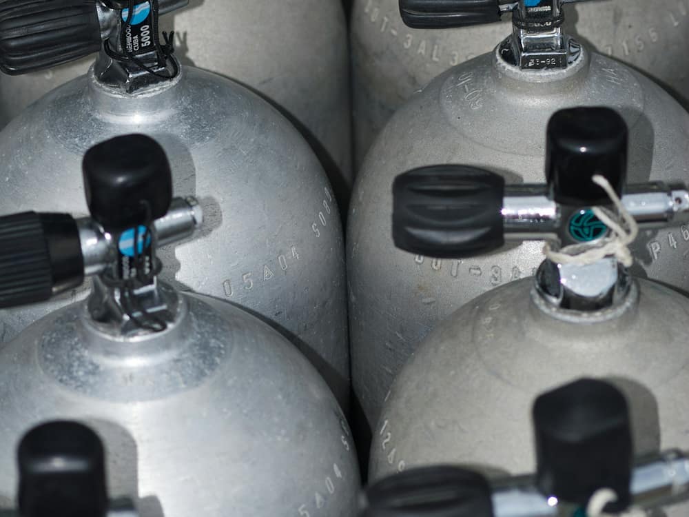 A row of scuba tanks with regulators fitted
